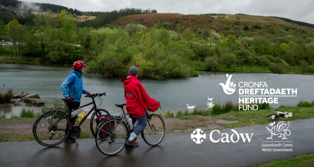 Two women with bikes looking out over a lake